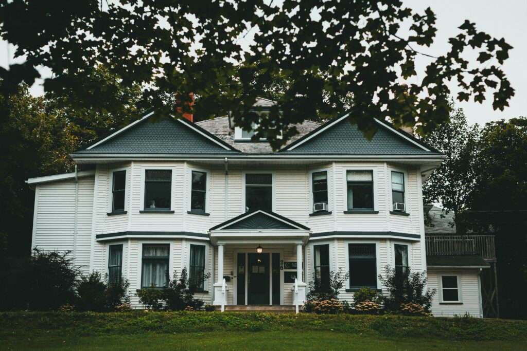 Victorian-style house exterior with a lush front yard, showcasing classic residential architecture.